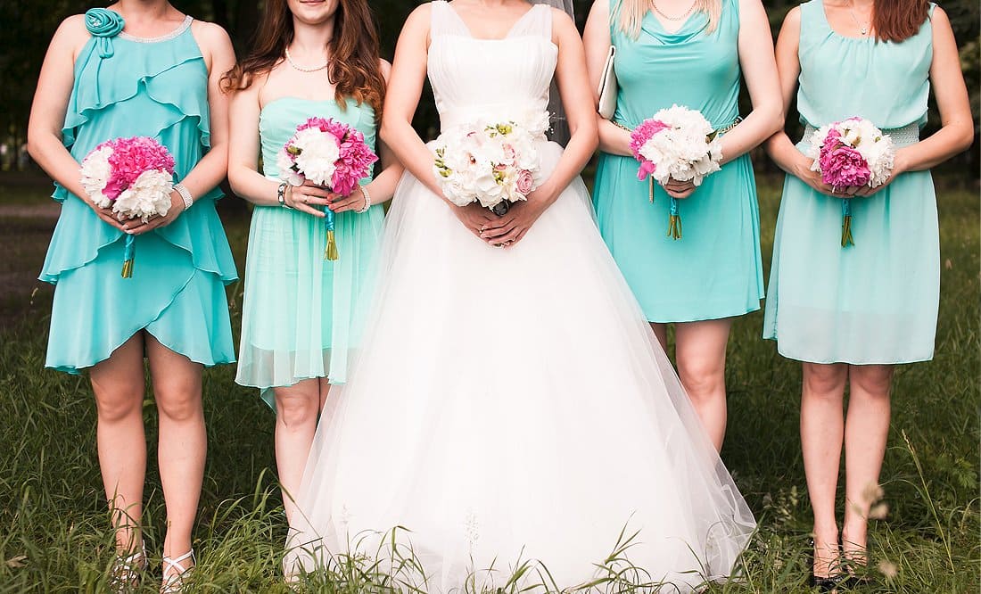 Braut inmitten ihrer Brautjungfern, jede trägt einen Blumenstrauß