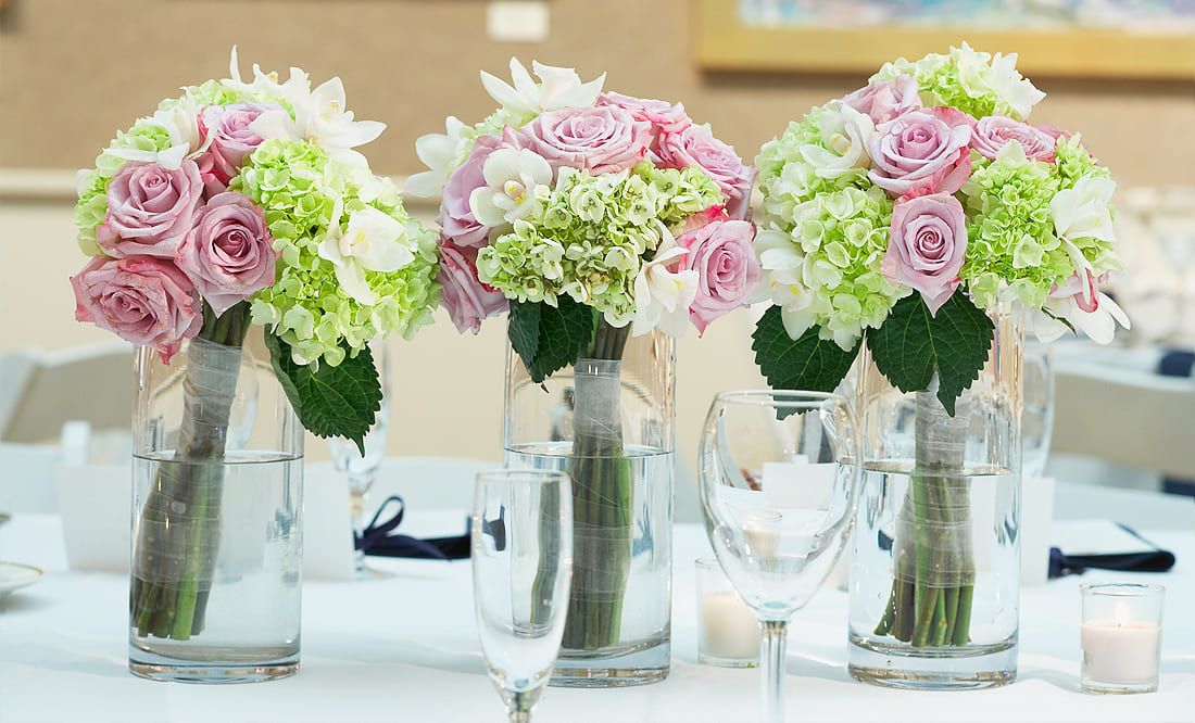 Frühlingshafte Tischdekoration mit Blumensträußen in rosa, weiß und grün gehalten